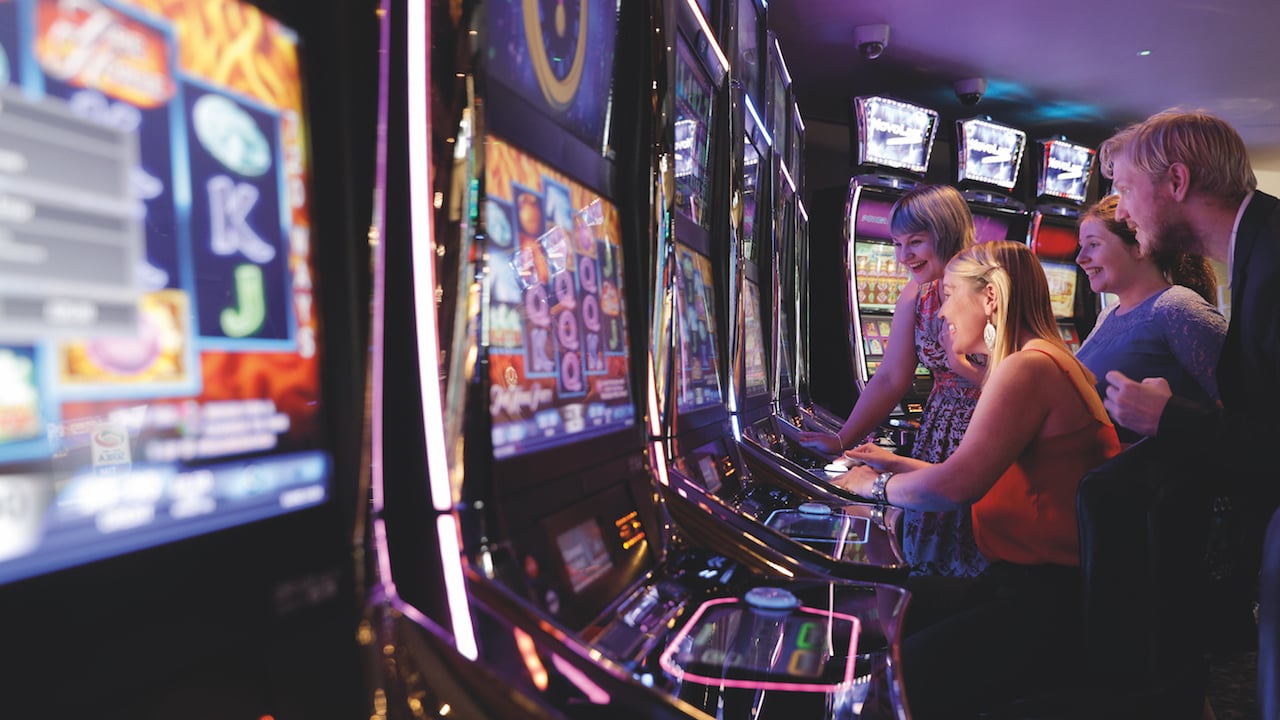 people gathered around a gaming machine in a casino