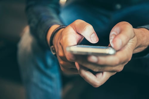 Midsection Of Man Using Mobile Phone