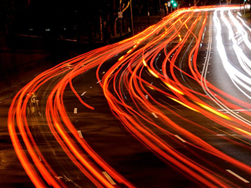 Long exposure showing the flow of multiple lanes of busy on a multi-lane urban road.