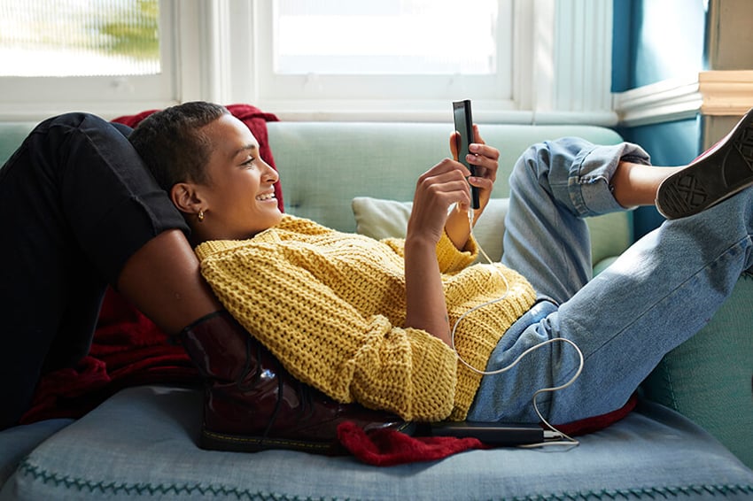 woman laying on couch looking at phone woman laying on couch looking at phone
