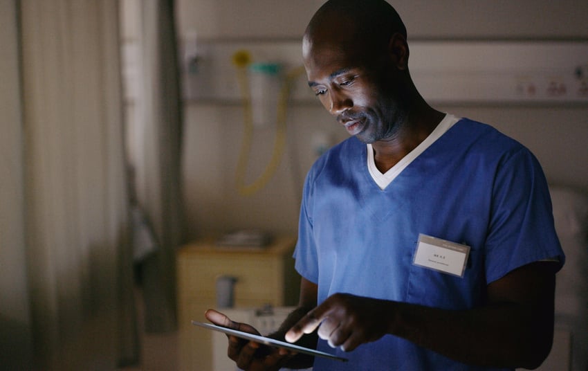 Open laptop with stethoscope, reading glasses and a closed chart
