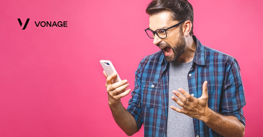 Photo of angry man holding his cellphone. He is looking at the screen and screaming in frustration.