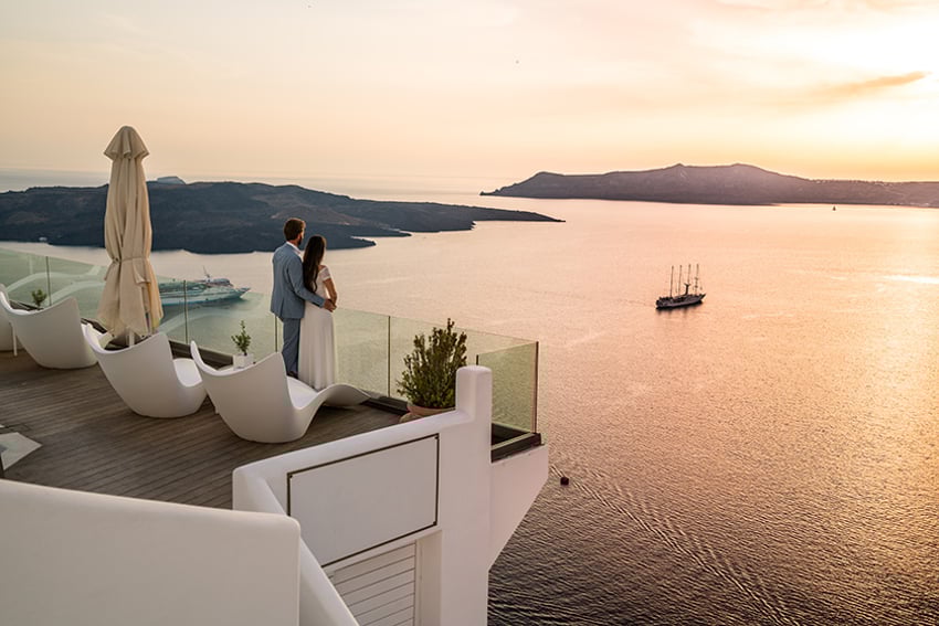 863505358 couple in lromantic location - luxury hotel in greece overlooking the sea.