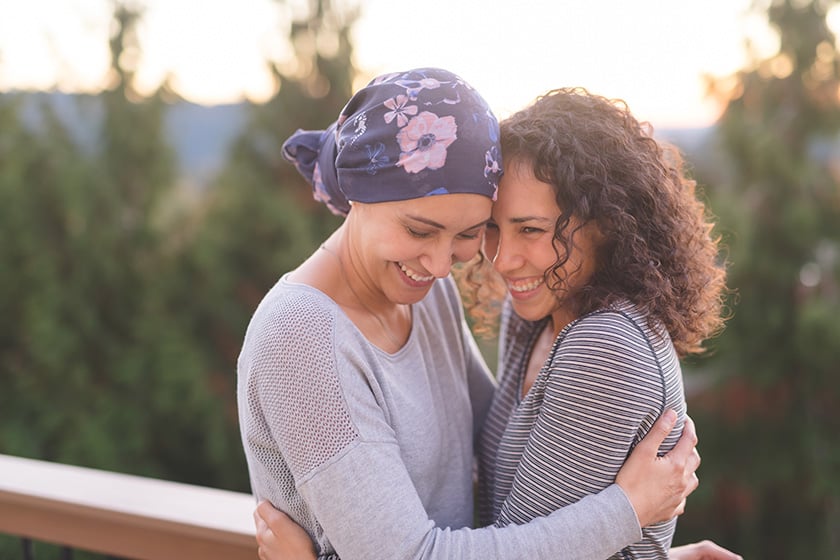Woman cancer patient hugging her friend